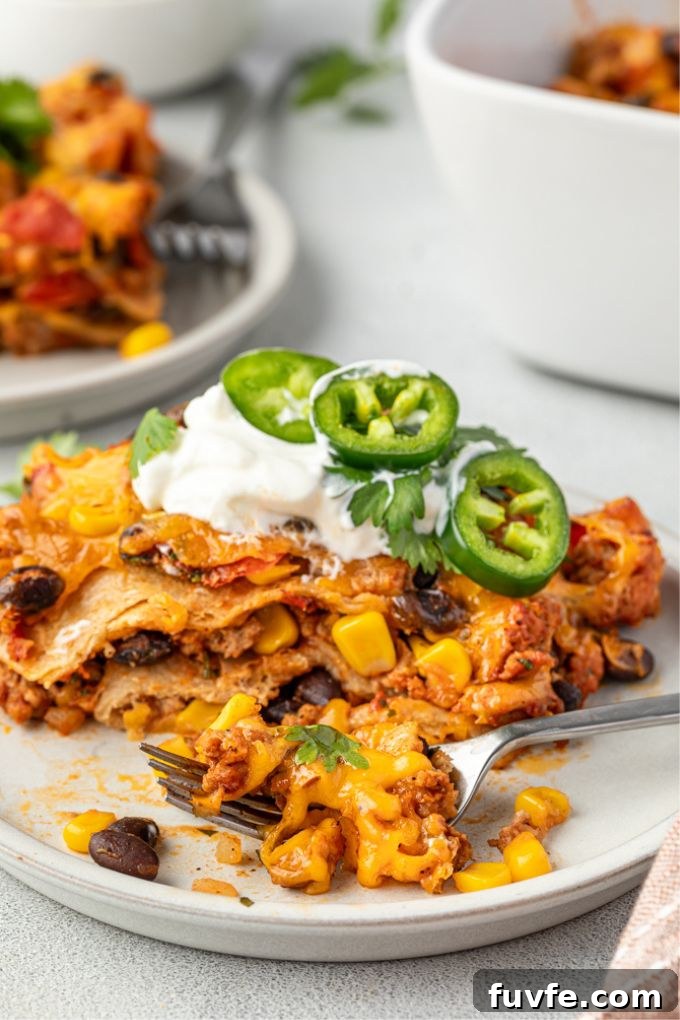 Cheesy Mexican Tortilla Casserole with Beans 8 Mexican lasagna on a plate with a bite out of it