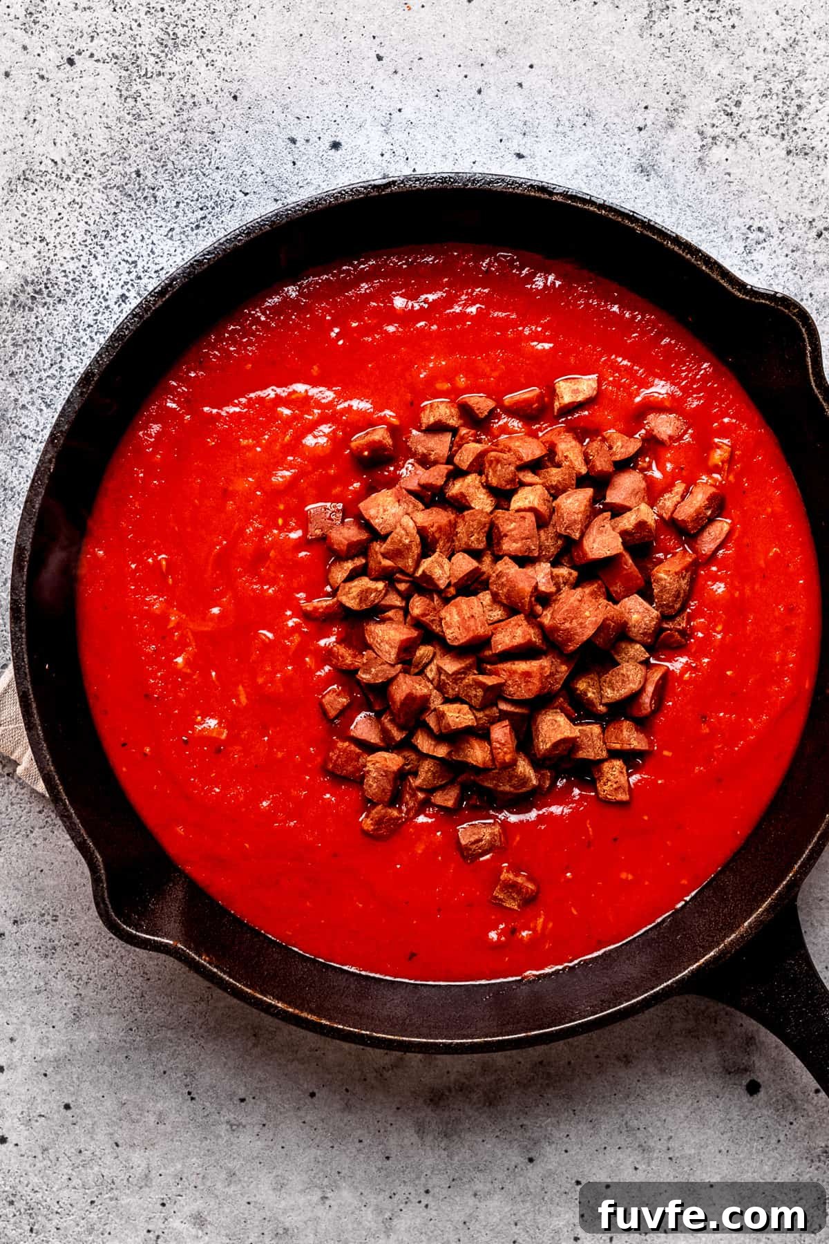 Tomato sauce with chorizo being added.