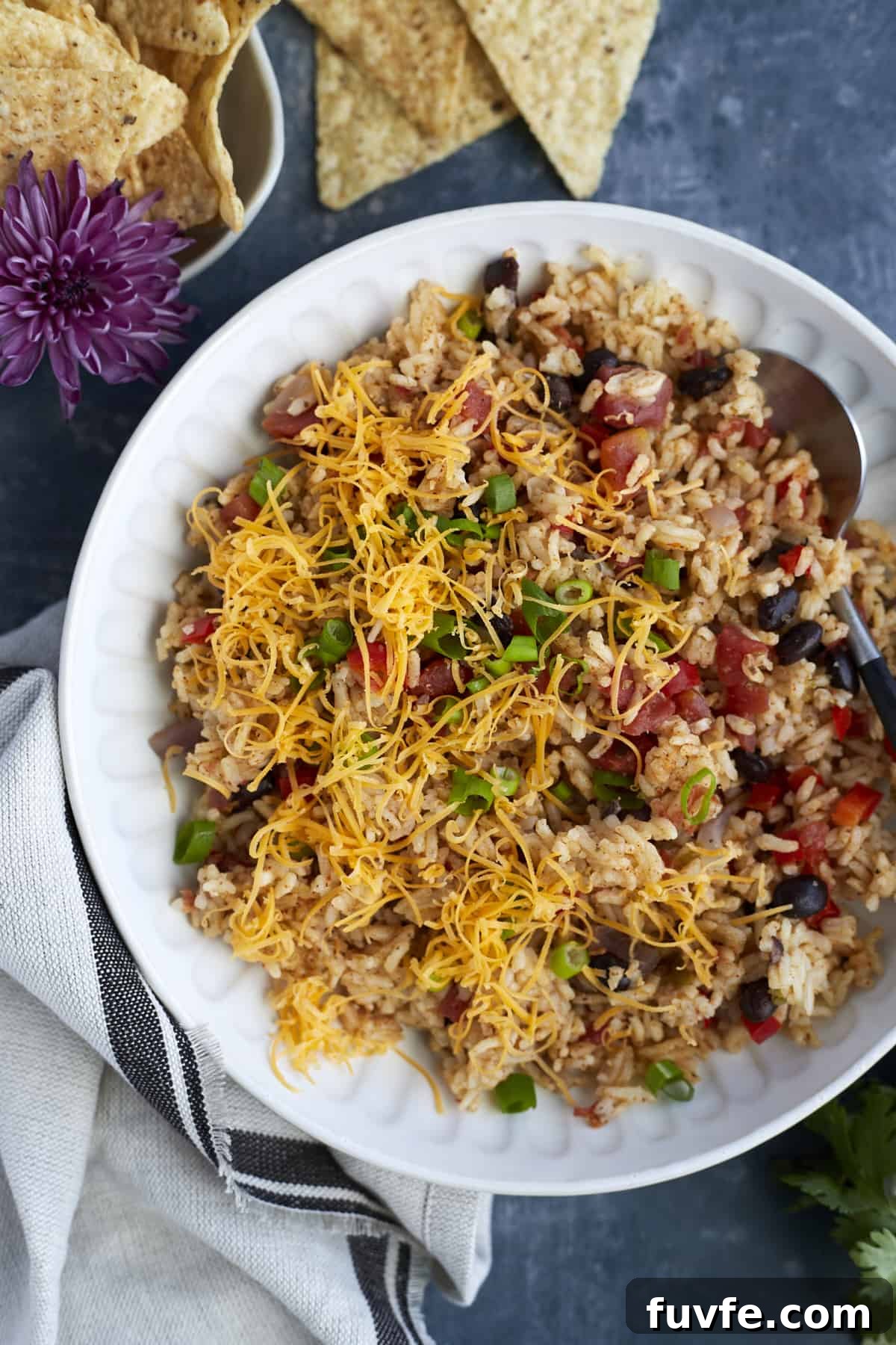 Overhead image of a white plate full of easy Mexican rice with cheese and veggies