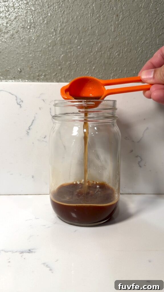 Banana Bread Latte Syrup Recipe — Homemade Coffee Flavoring 11 adding banana bread syrup to a shot of espresso
