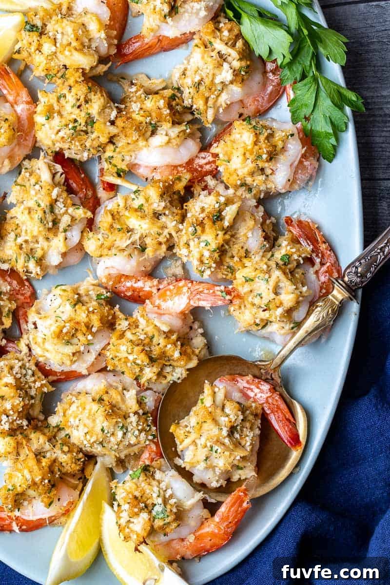 Oven-Baked Stuffed Shrimp with Garlic Herb Breadcrumbs 2 platter with crab stuffed shrimp with serving spoon and lemon wedges.