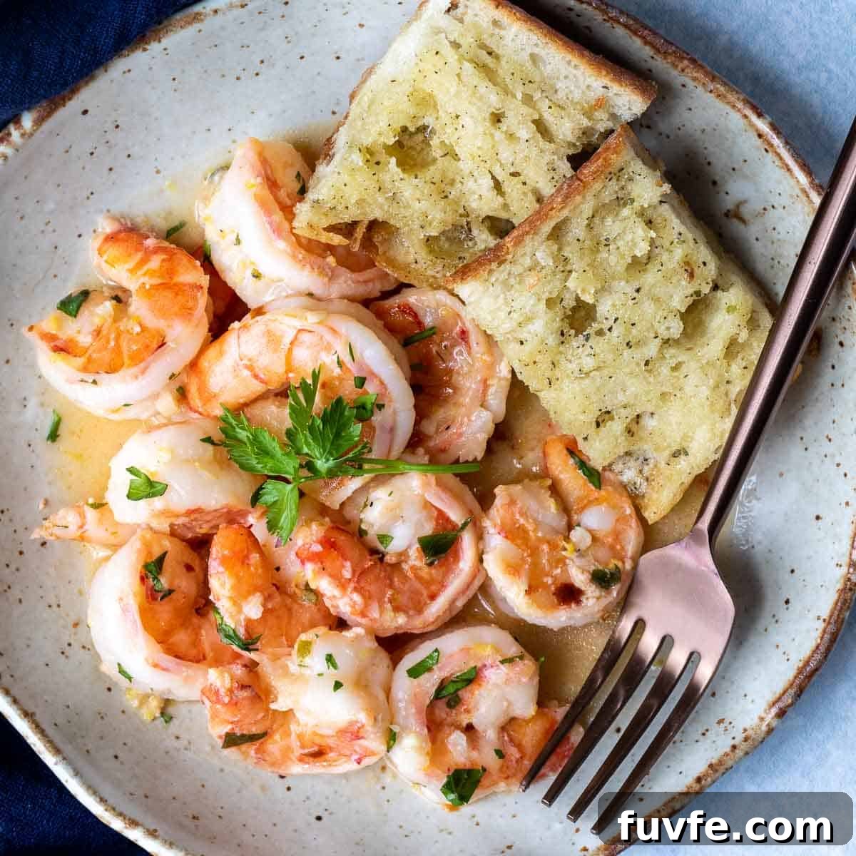overhead view of shrimp scampi with garlic bread.