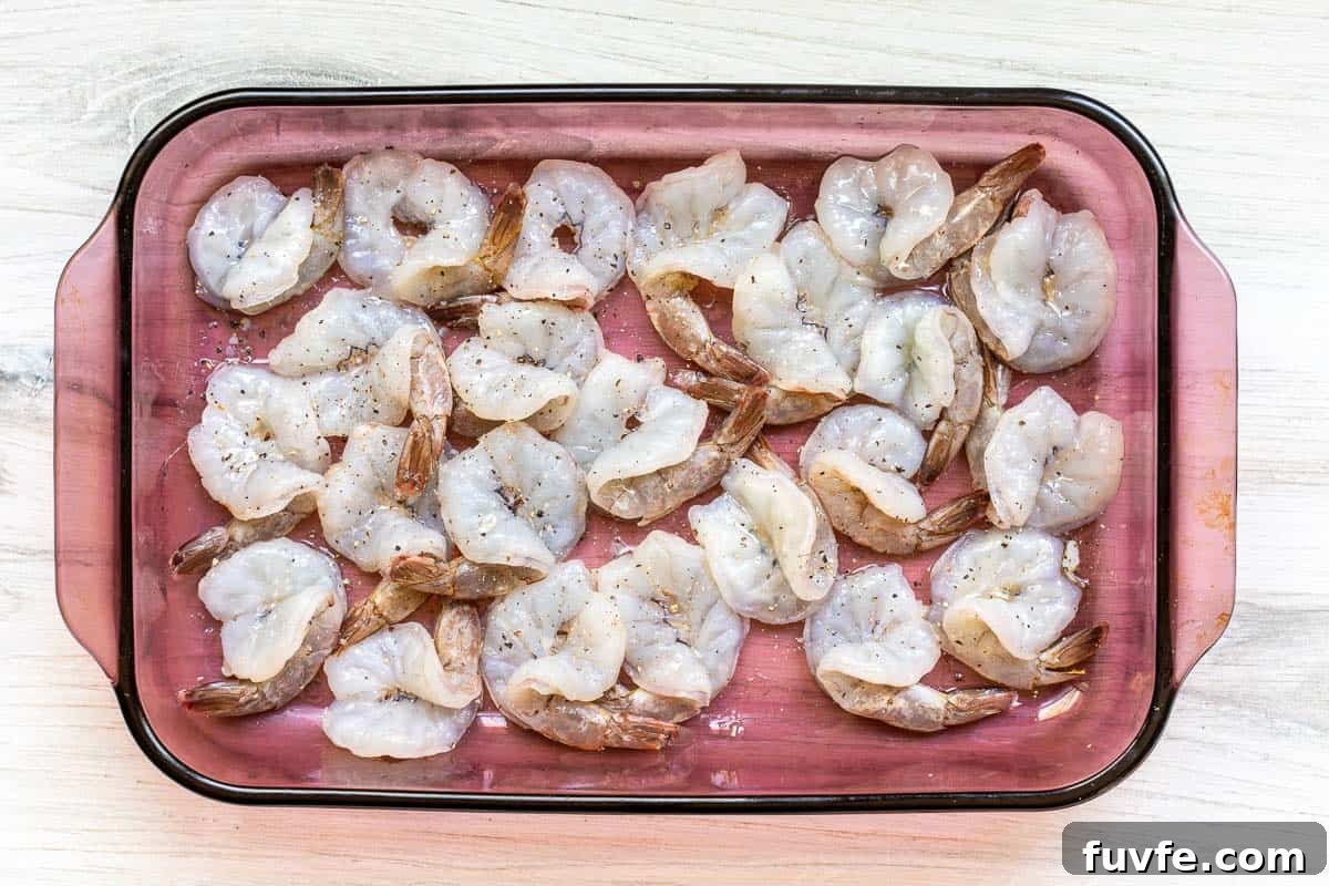 Oven-Baked Stuffed Shrimp with Garlic Herb Breadcrumbs 6 butterflied shrimp seasoned with salt and pepper in baking dish.