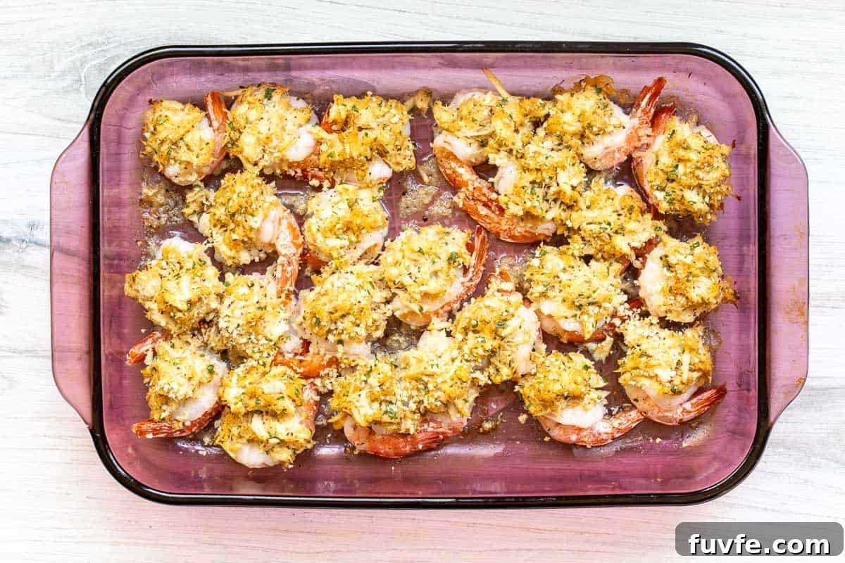 Oven-Baked Stuffed Shrimp with Garlic Herb Breadcrumbs 9 baked crab stuffed shrimp in baking dish.