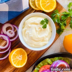 Homemade Mayonnaise Recipe: Smooth, Creamy, and Stable 12 mayonnaise recipe in bowl next to lemons and a sandwich.