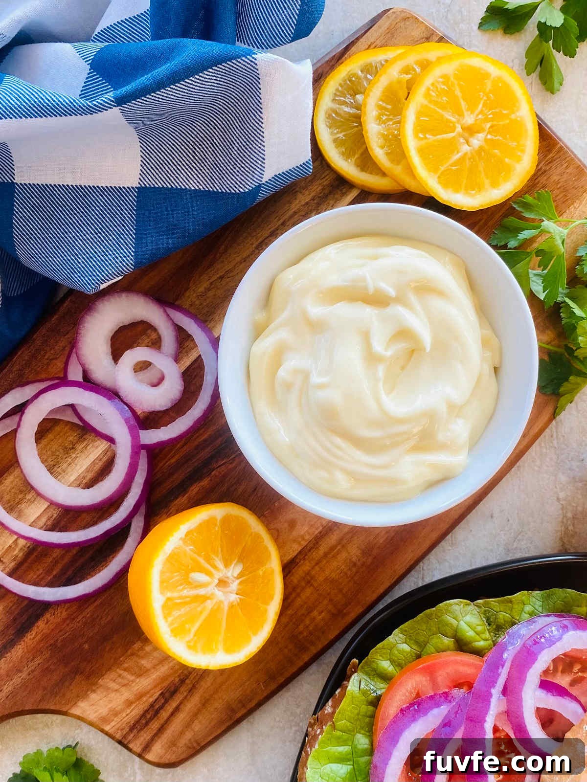 Homemade Mayonnaise Recipe: Smooth, Creamy, and Stable 7 mayo recipe in a bowl next to lemon and sliced onion.