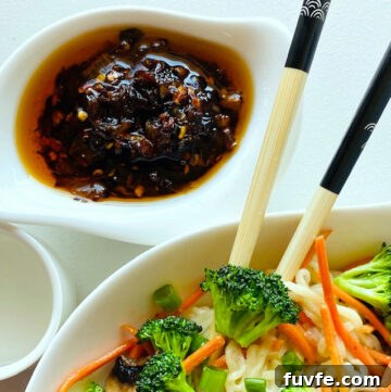 chili-crisp-in-dish-and-bowl-of-noodles-vegetables-and-chopsticks