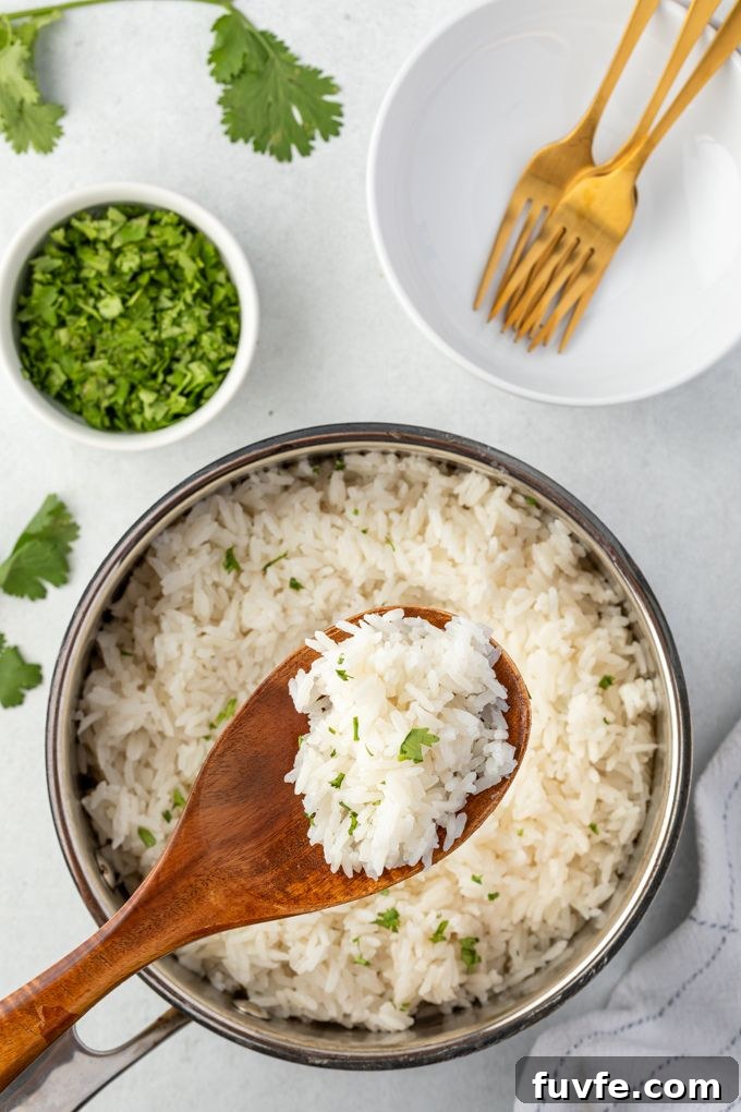 How to Make Coconut Rice (Creamy Jasmine Rice) 6 Coconut milk rice in a pot with a spoon