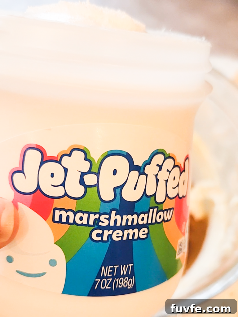 a hand holds a jar of Jet-Puffed marshmallow creme