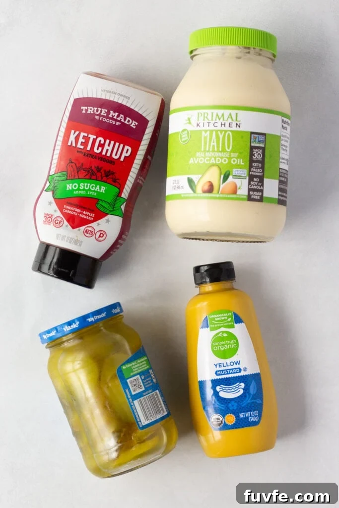 Quick 4-Ingredient Burger Sauce Recipe for Classic Flavor 3 Top down shot of bottles and jars of mayo, ketchup, yellow mustard, and dill pickles on a white background