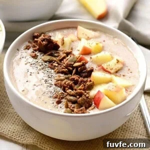 A bowl of oatmeal with apples.