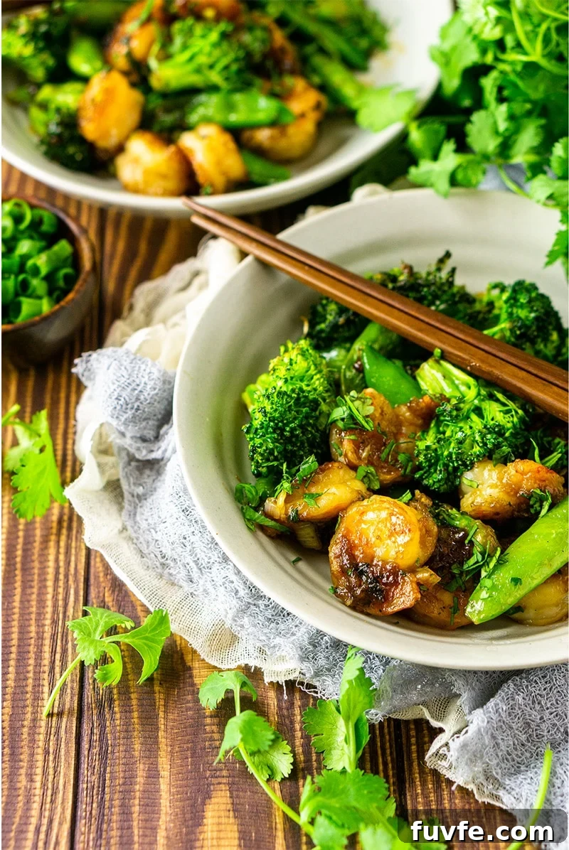 Bowl containing sauteed shrimp with stir fry vegetables.
