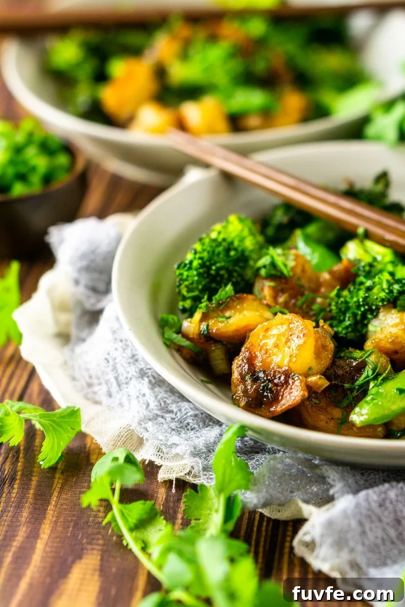 Shrimp stir fry in a bowl with broccoli, chopsticks on bowl.