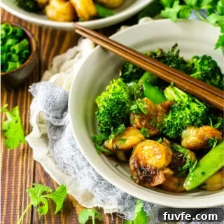 Bowl containing sauteed shrimp with stir fry vegetables.