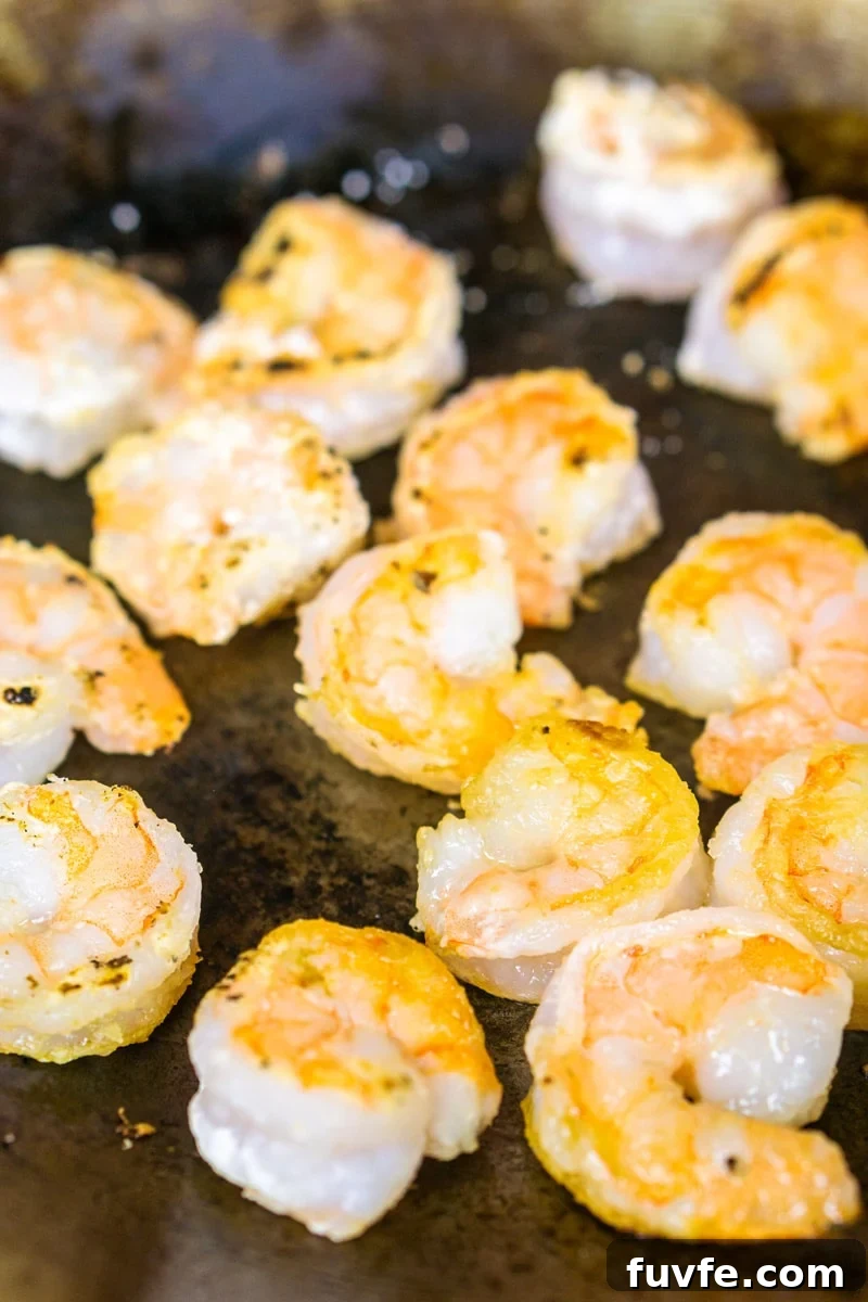 Shrimp being sauteed in a skillet.
