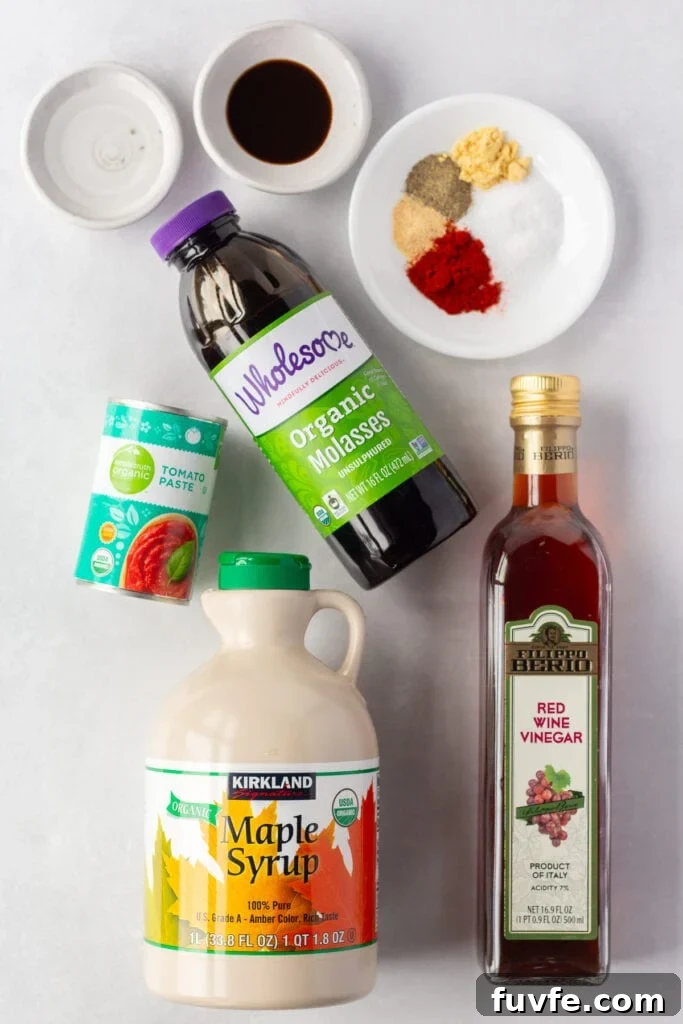 Top down shot of ingredients for maple bbq sauce, including maple syrup, red wine vinegar, molasses, worcestershire sauce, spices, and tomato paste.