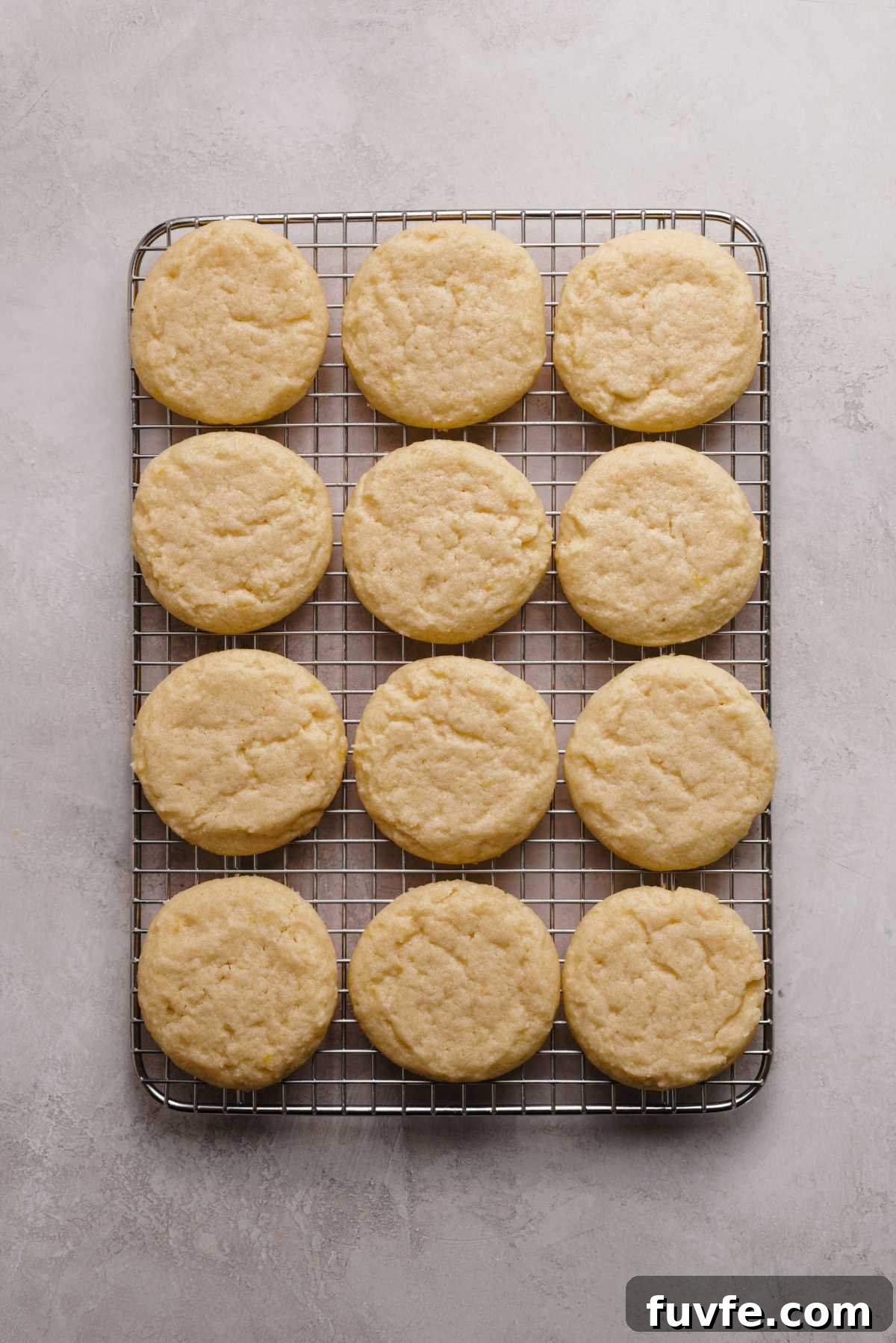 Lemon shortbread cookies cooling on a wire cooling rack on a grey marbled background.