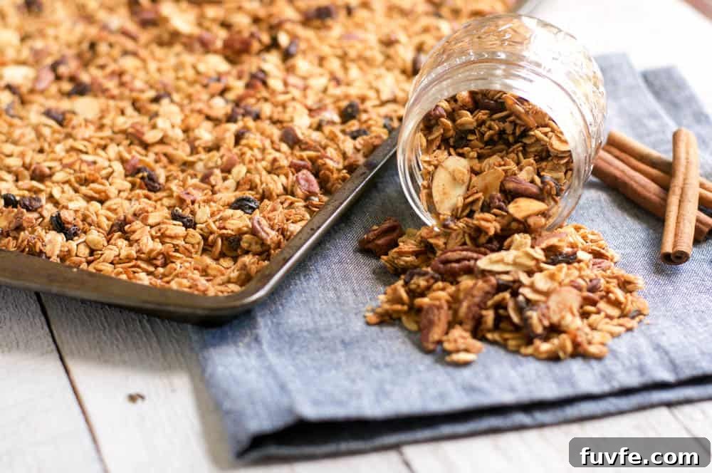Homemade Maple Pecan Granola Recipe for Crunchy Breakfast 2 Maple Pecan Granola on baking sheet with granola filled jar pouring out.