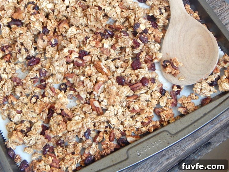 Homemade Maple Pecan Granola Recipe for Crunchy Breakfast 3 Maple pecan granola on sheet pan with spoon.