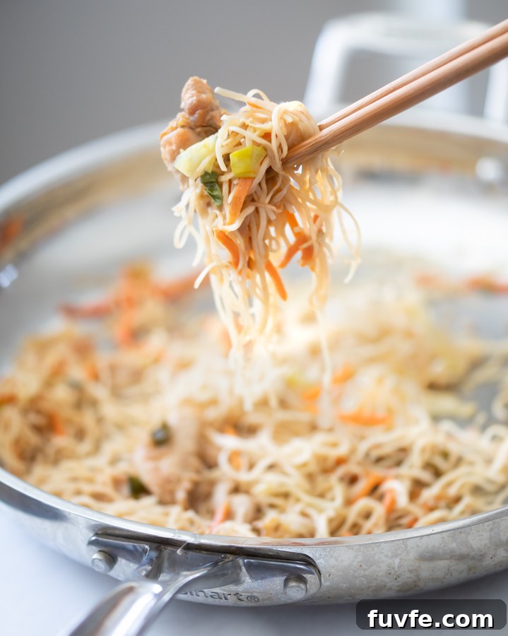 Chicken Chow Mein: Quick Homemade Takeout-Style Recipe 5 A photo of easy chicken chow mein recipe. Holding the chow mein with chopsticks