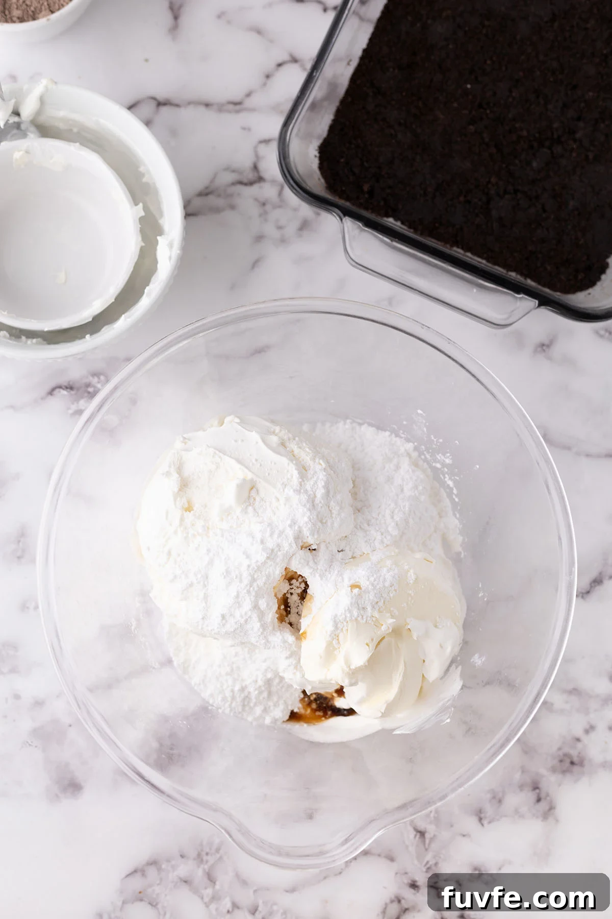 Cool whip, cream cheese, vanilla, and powdered sugar in a mixing bowl.