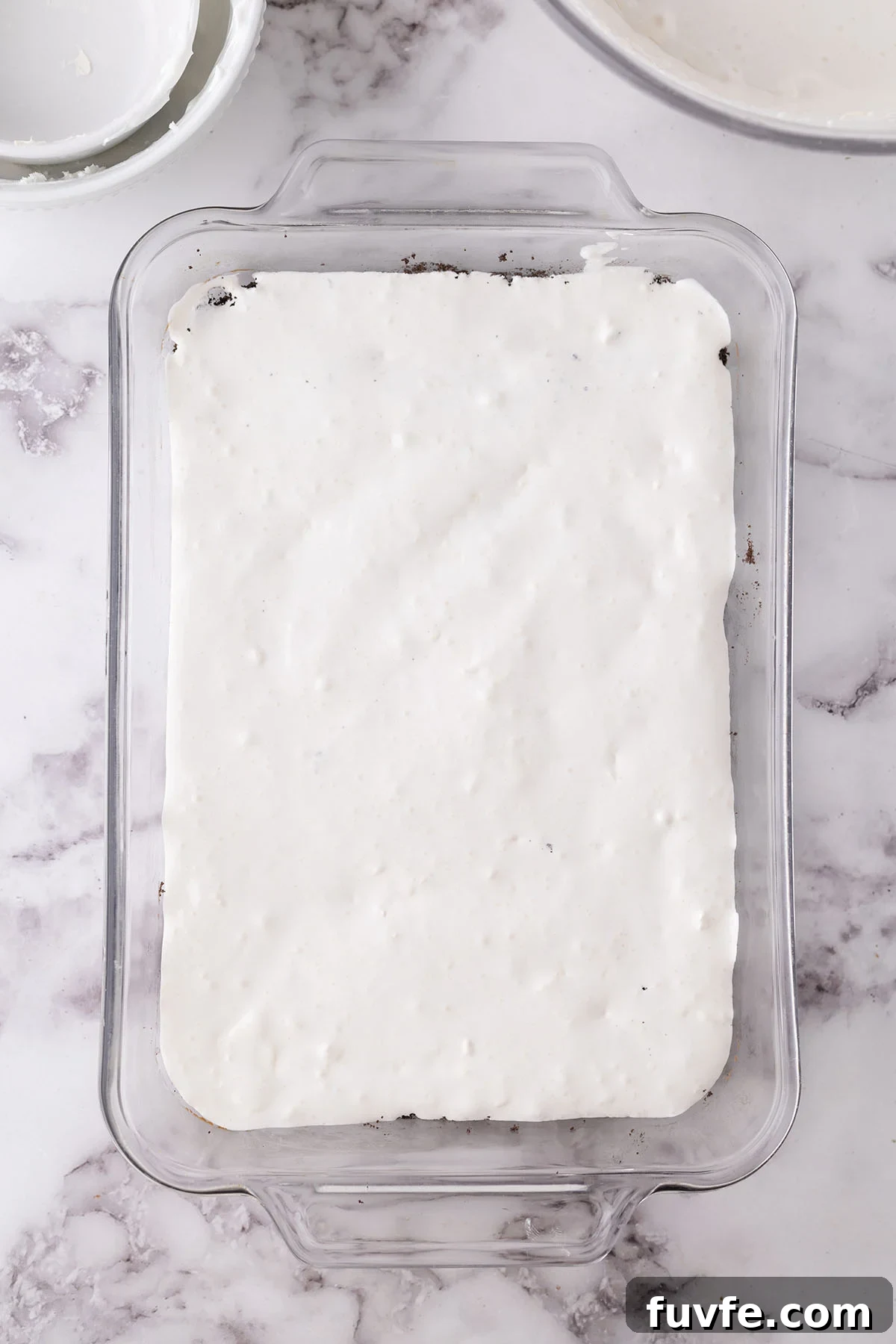 Vanilla cool whip layer in the baking dish.