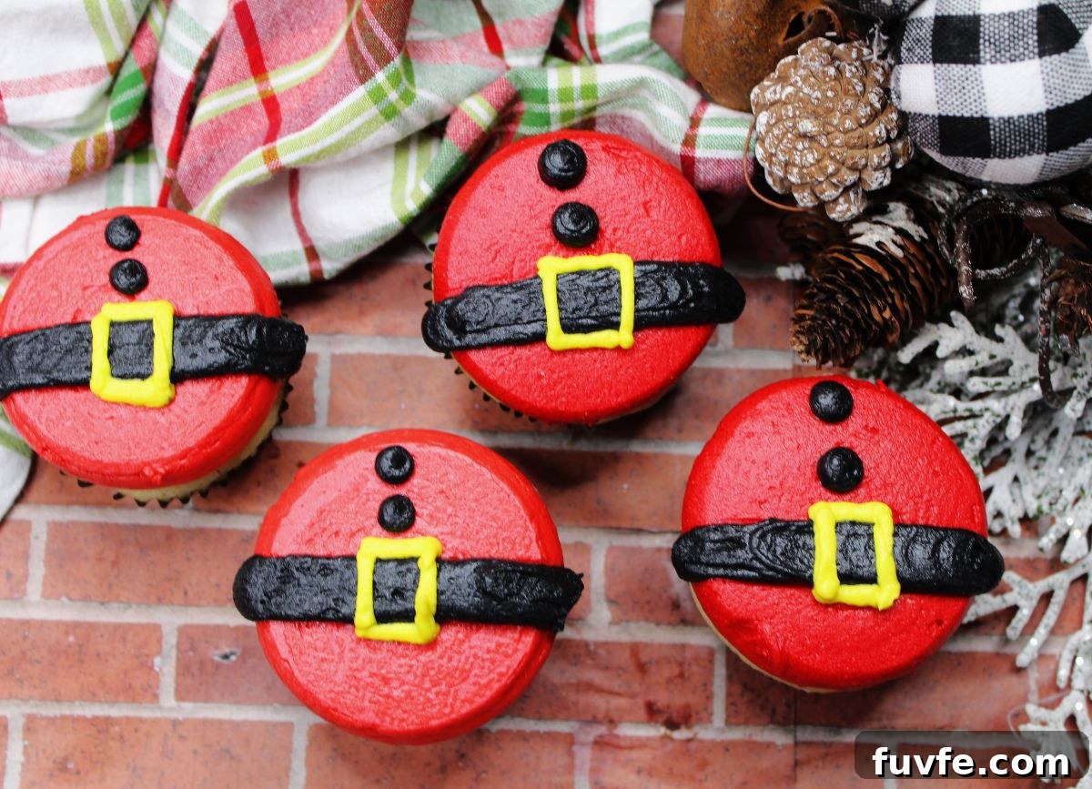 A handful of decorated Santas belt and belly cupcakes.