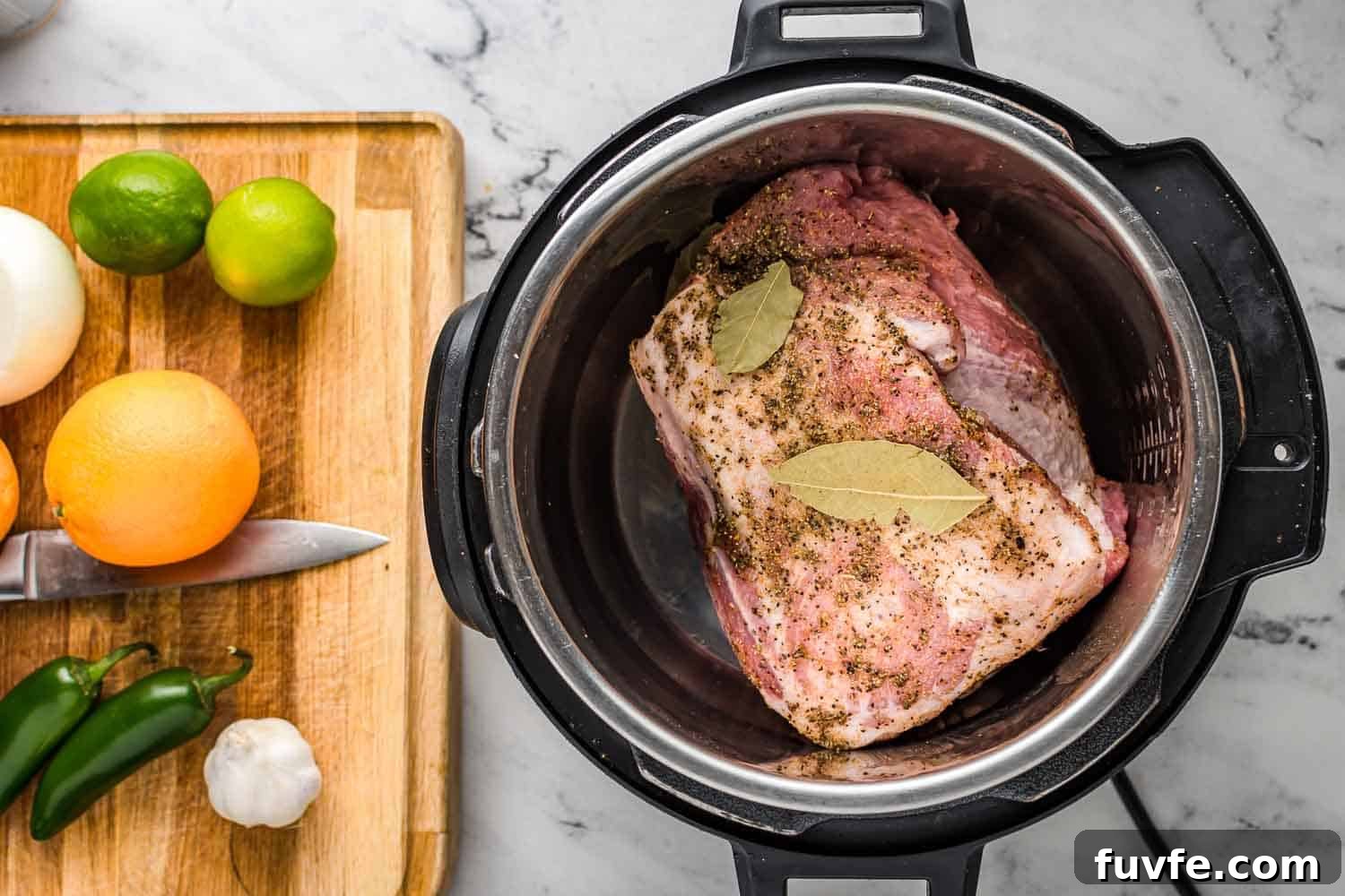 Authentic Instant Pot Carnitas Recipe for Tender Mexican Pork 4 Pork shoulder in the instant pot, and a cutting board with limes, oranges, jalapeños, garlic.