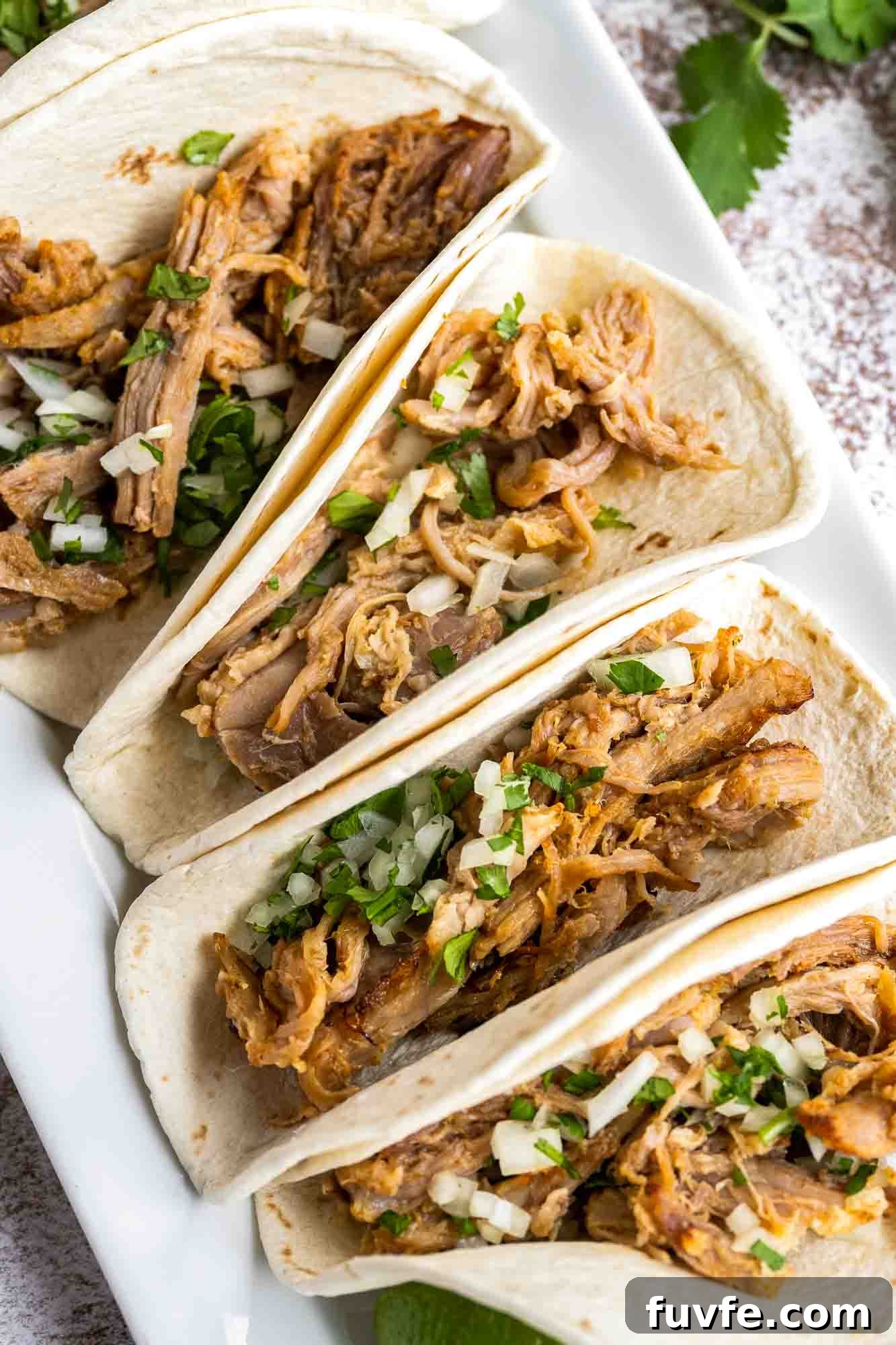 Authentic Instant Pot Carnitas Recipe for Tender Mexican Pork 7 Carnitas tacos in a white platter