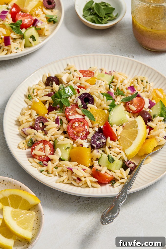 Greek Orzo Salad with Feta, Olives and Lemon Dressing 7 Orzo Greek salad on a serving plate with a fork.