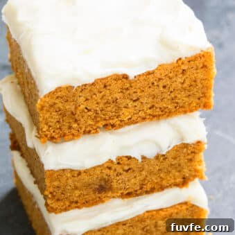 Stack of Easy Pumpkin Bars With Cream Cheese Frosting on Rustic Gray Background