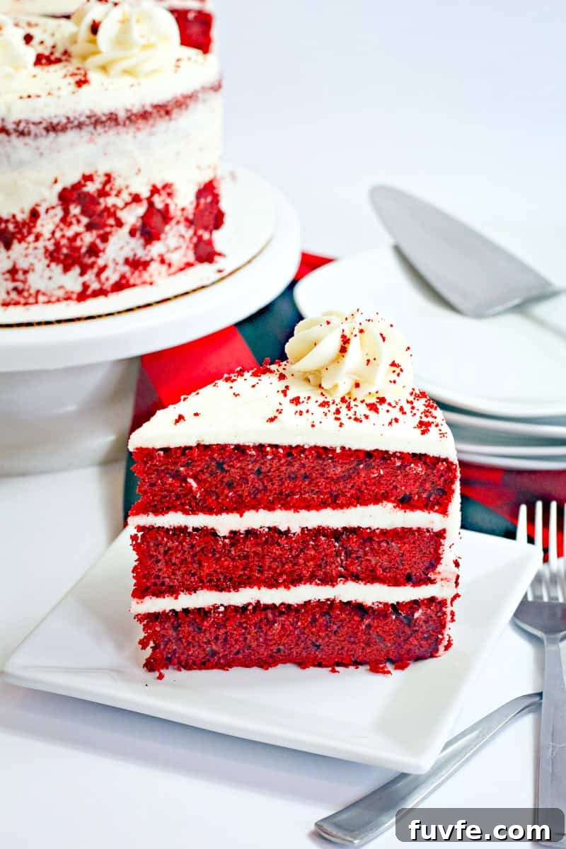 Moist Red Velvet Cake Made With Buttermilk 2 a 3 layer slice of red velvet cake with cream cheese frosting and cake crumbs.