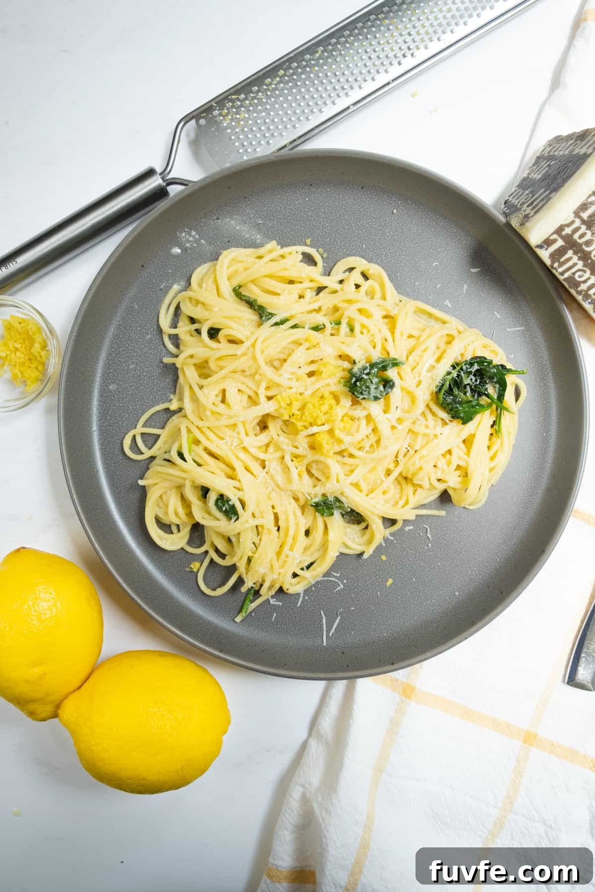 Lemon Spinach Pasta Recipe: Bright 20-Minute Weeknight Meal 2 Lemon spinach pasta with lemons, zest and pecorino on side.