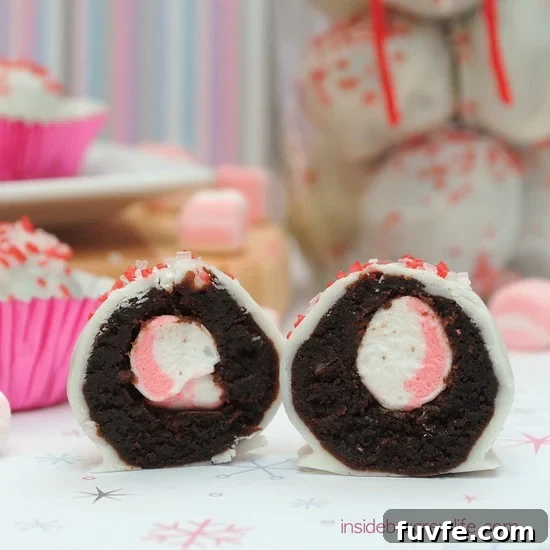 A jar of peppermint marshmallow brownie bites with one brownie bite cut in half in the front