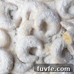 Vegan vanillekipferl on an icing sugar dusted surface.