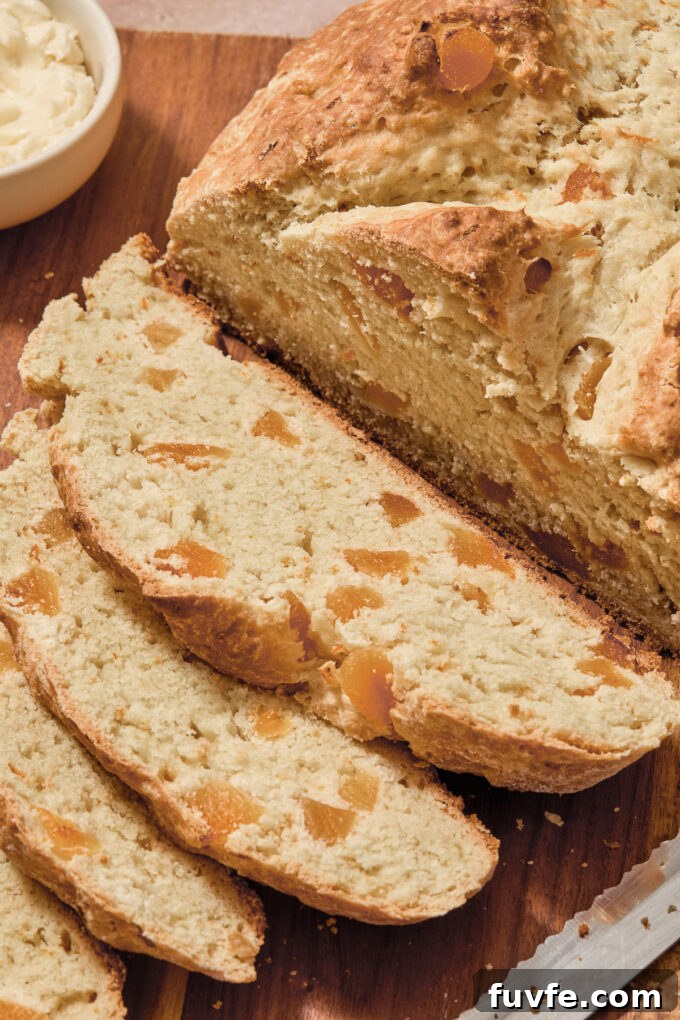 Irish soda bread with orange zest sliced on a cutting board.