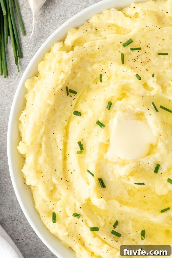 Yukon mashed potatoes in a bowl with butter and chopped chives