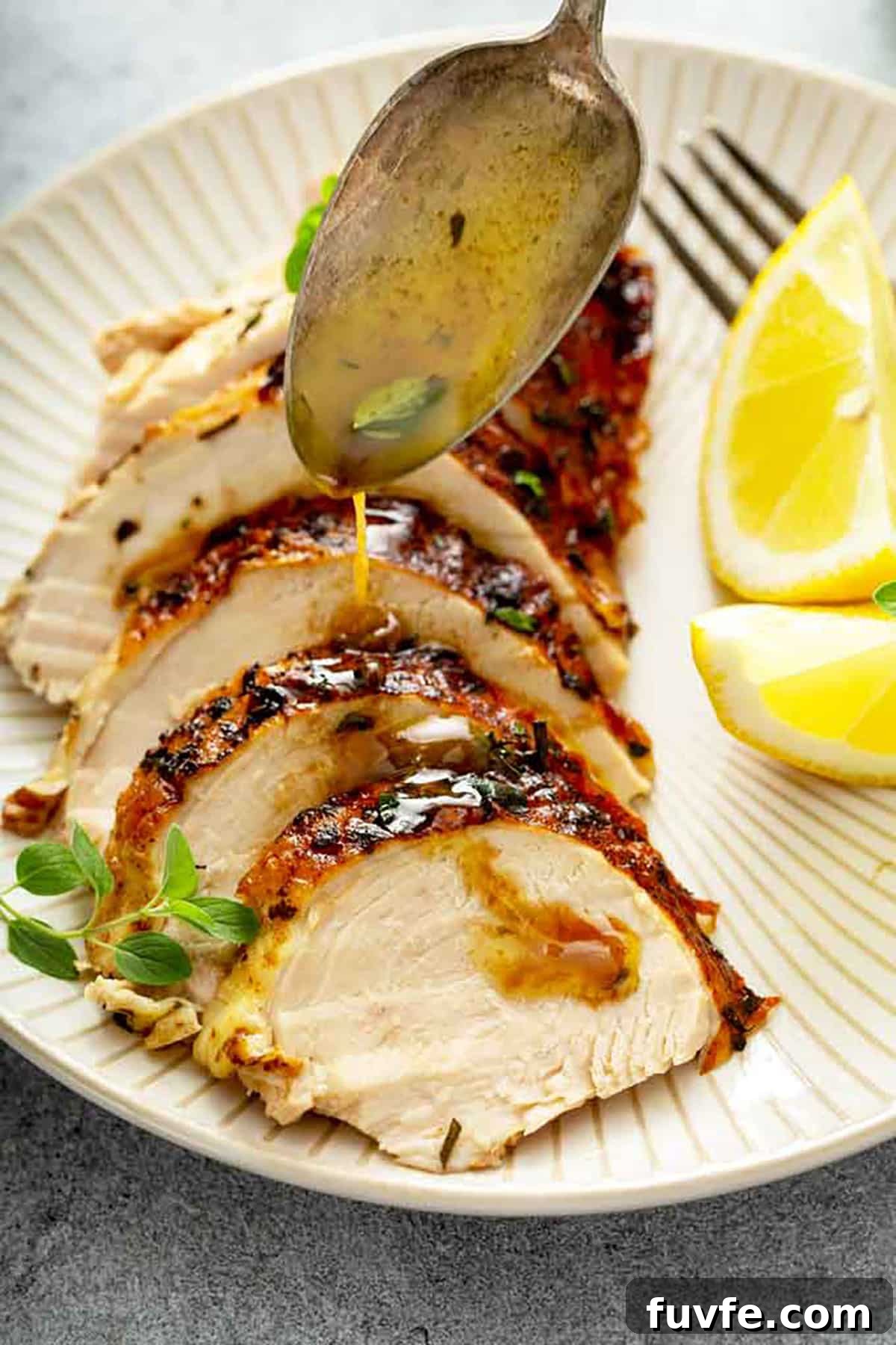 Herb-Butter Roast Chicken Recipe for Juicy Crispy Skin 3 Pan juices from roasting a chicken getting poured over sliced chicken breast.