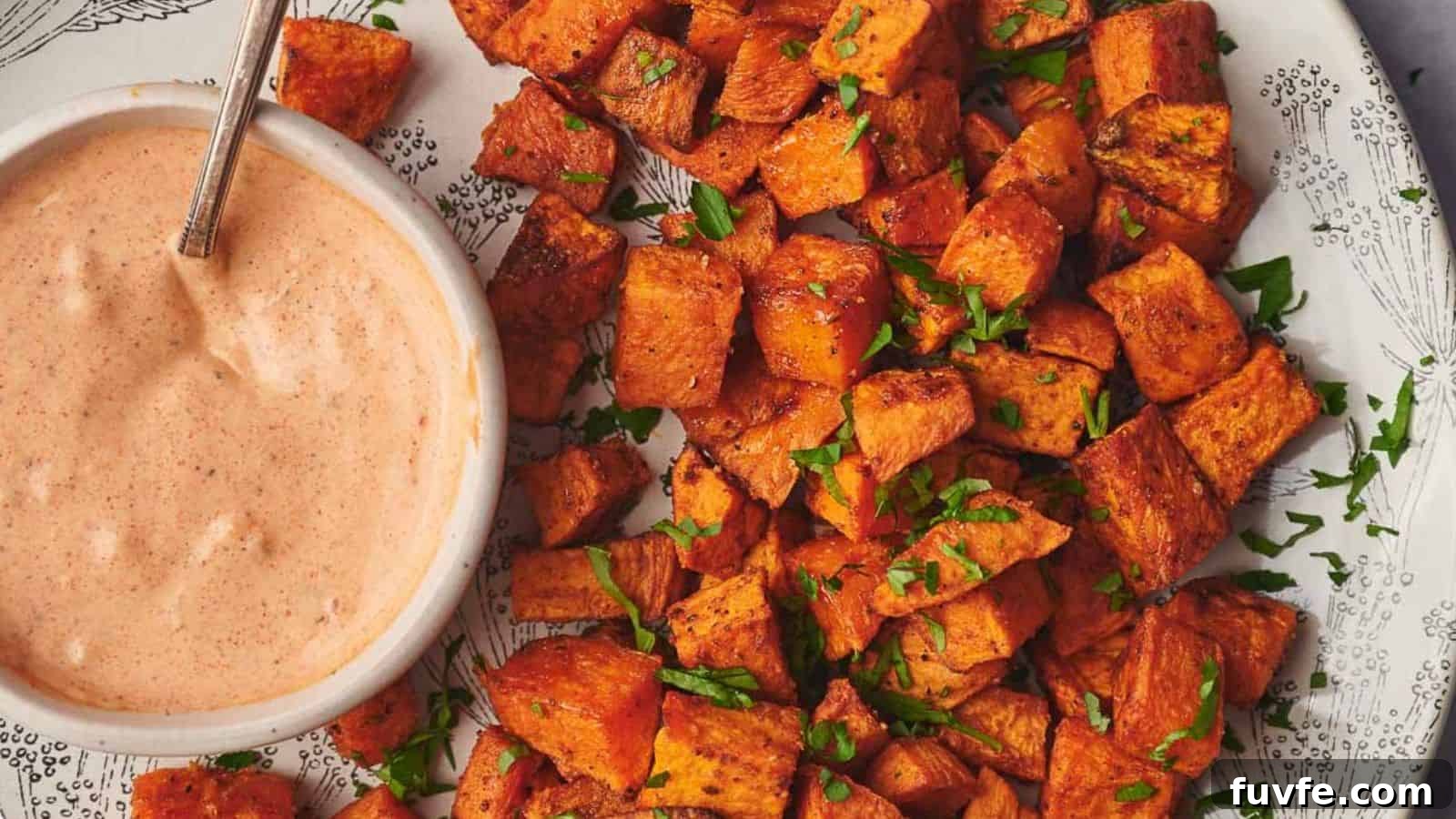 Sweet potato cubes on a plate with a dipping sauce.