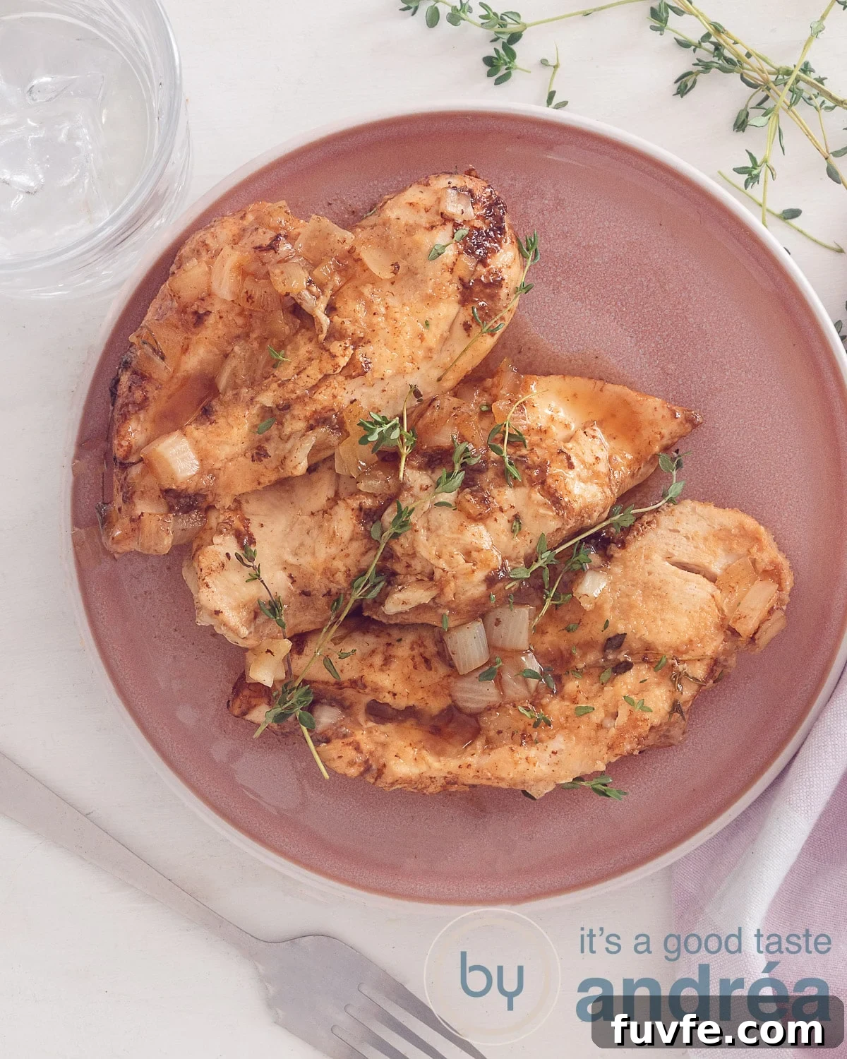 Brown Sugar Garlic Chicken Slow Cooker Recipe for Tender, Sticky Wings 2 A photo from above of a pink plate with three brown sugar chicken breast filet prepared in the slow cooker. A white background.
