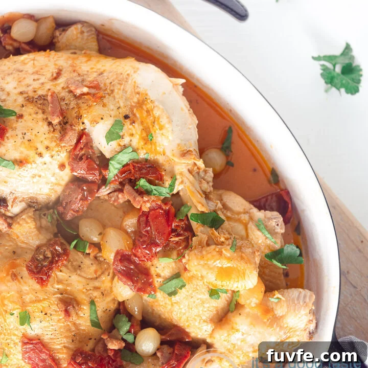 a casserole with coq au vin blanc, bacon and tomatoes