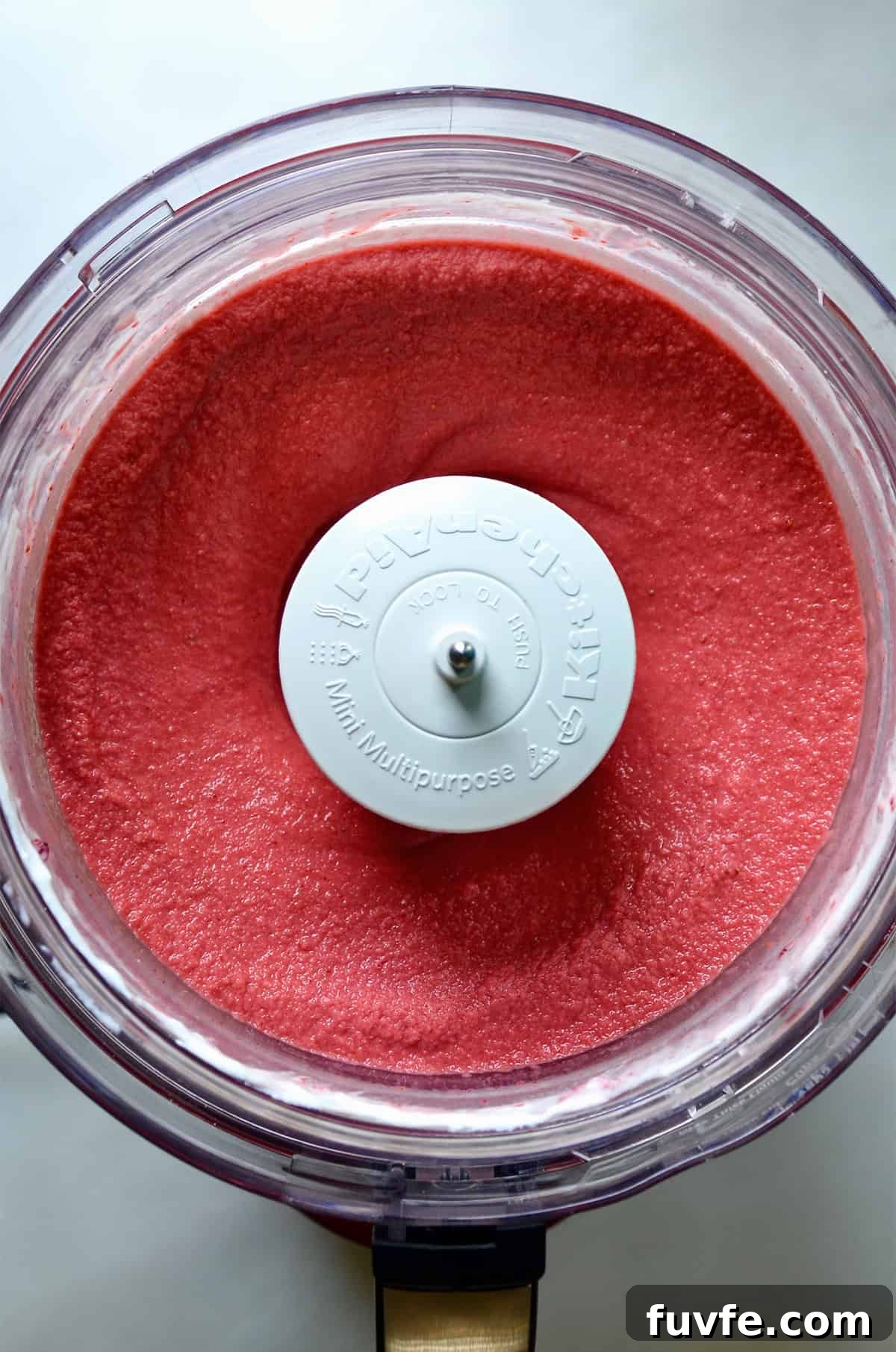 Quick Strawberry Frozen Yogurt Recipe Ready in 5 Minutes 5 Creamy strawberry frozen yogurt in the bowl of a food processor.