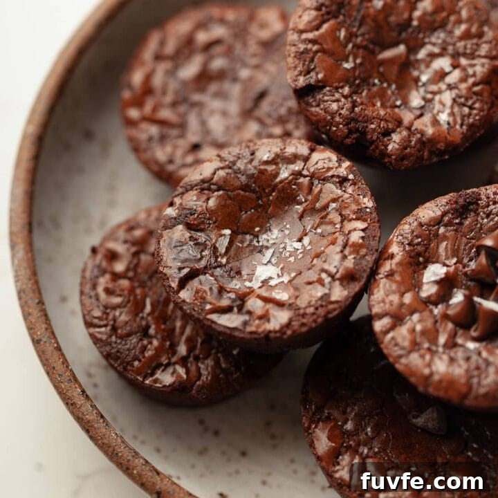 gluten free brownie bites with a crinkle crust and topped with some flaky sea salt