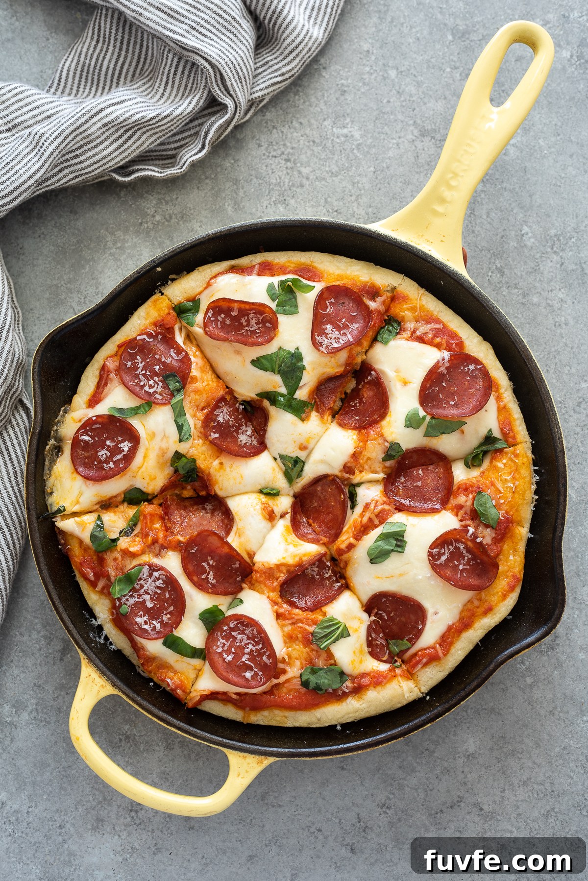 Focaccia bread pizza with pepperoni and basil on top.
