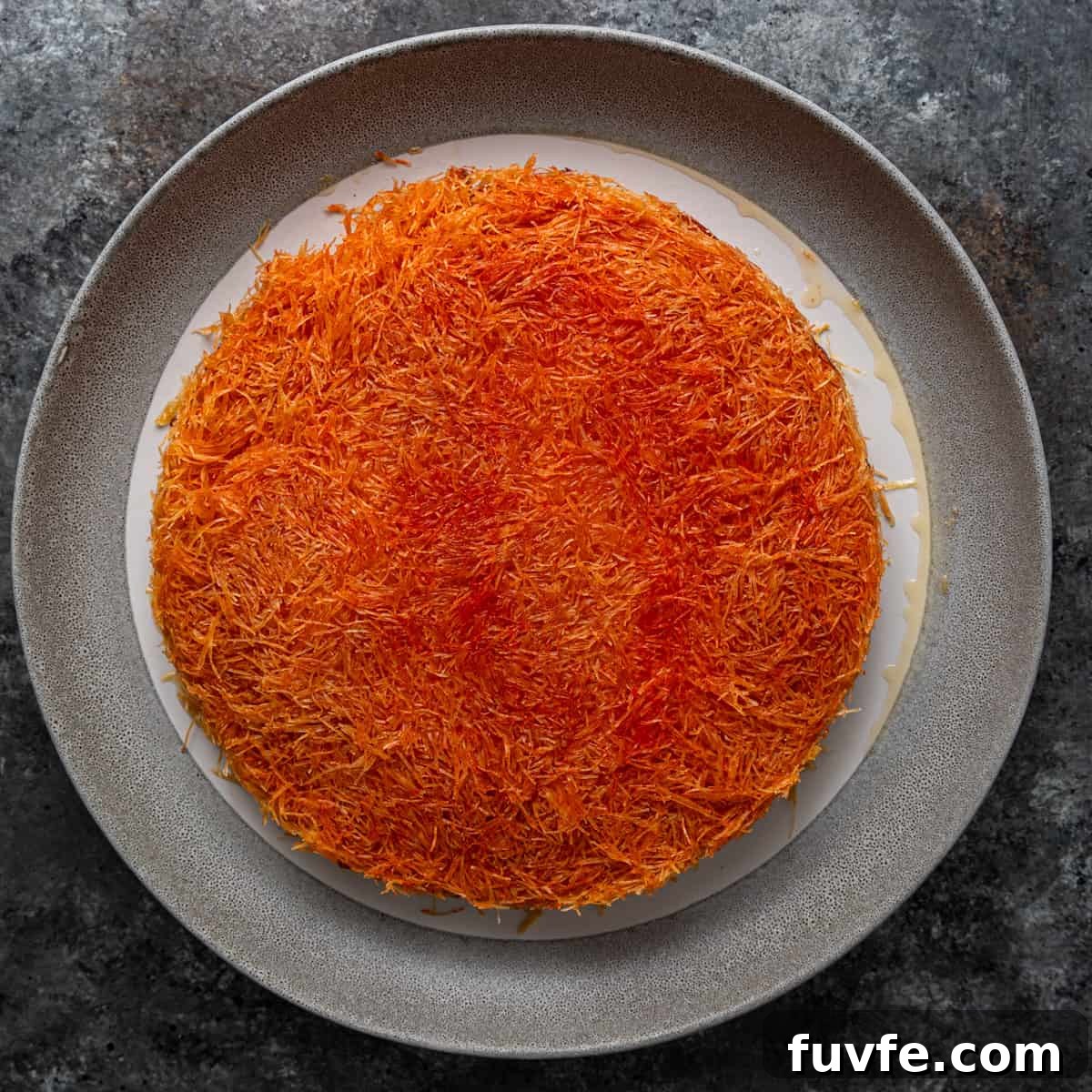 overhead: baked knafeh with orange colored layer visible