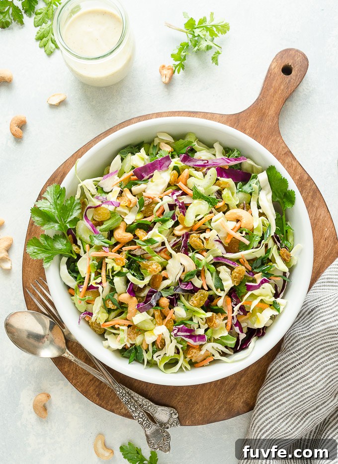 Overhead view of curry coleslaw with cashews and golden raisins