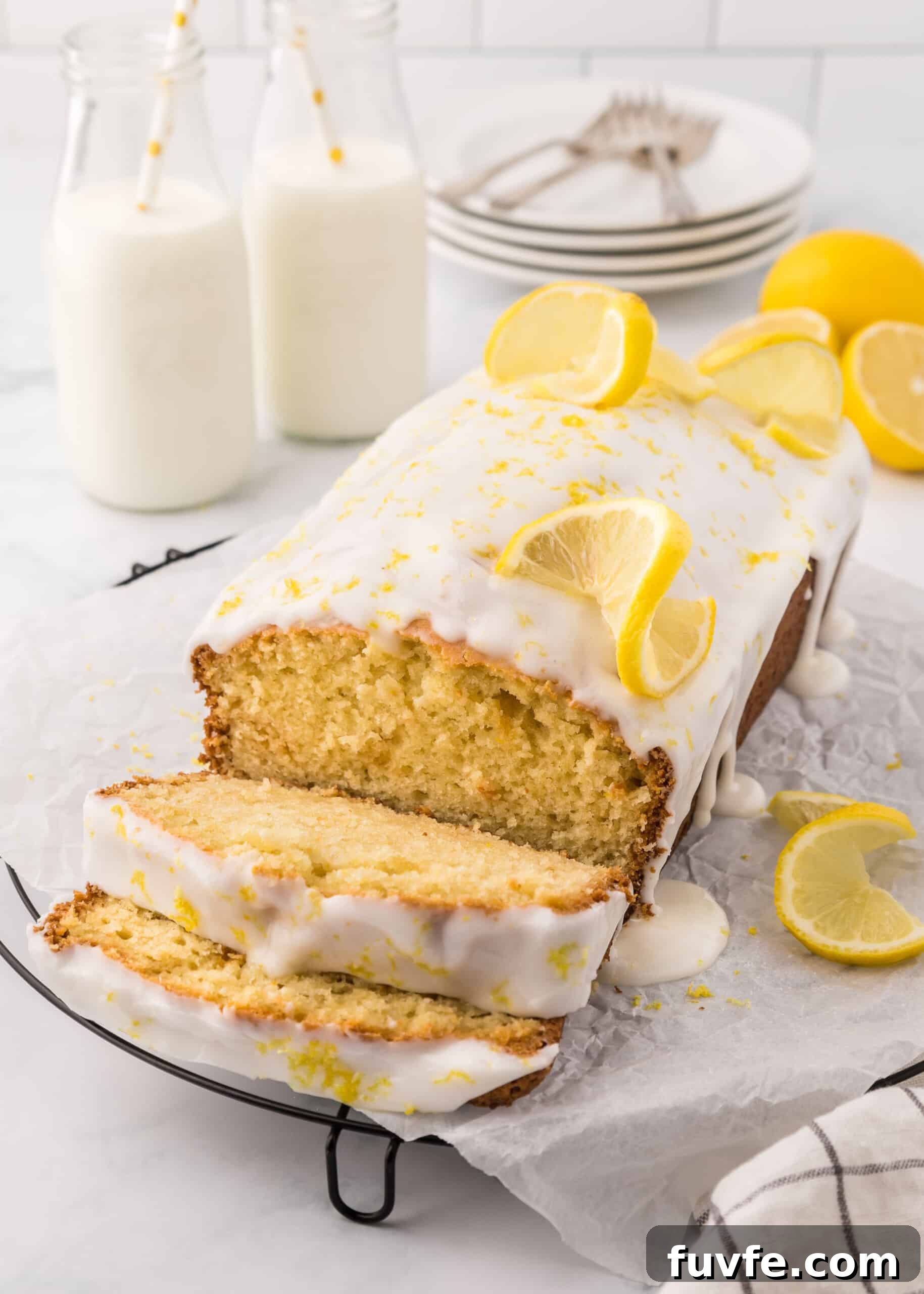 Zesty Iced Lemon Loaf Recipe for a Moist Citrus Cake 3 Lemon loaf with icing sprinkled with lemon zest and topped with lemon slices.