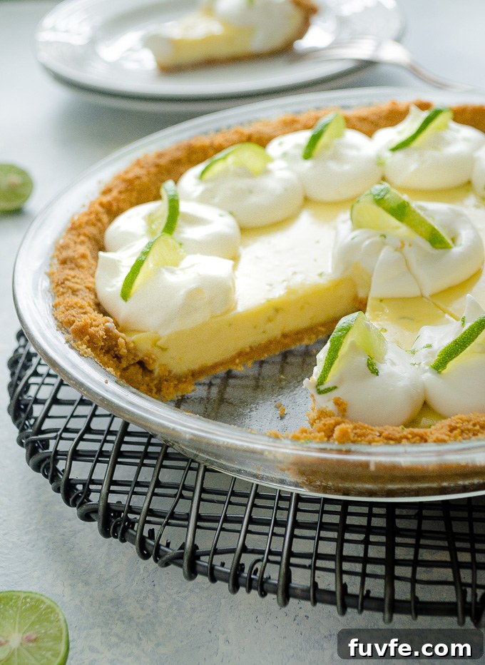 Authentic Key Lime Pie Recipe with Creamy Filling 6 Key lime pie in pie plate with a slice missing