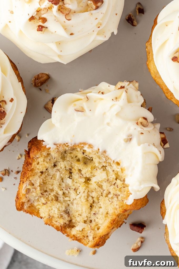 Half of a hummingbird cupcake laying on a plate next to more cupcakes 