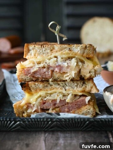 Kielbasa sandwiches stacked on top of each other with condiments on the side.